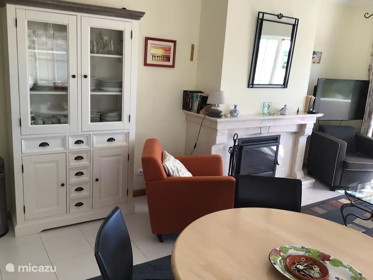 Sitzecke mit eingebautem Holzofen und modernem Fernseher