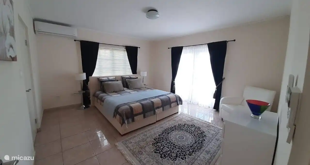 Slaapkamer 2 op de 1e verdieping met openslaande deuren naar balkon met uitzicht op de achtertuin