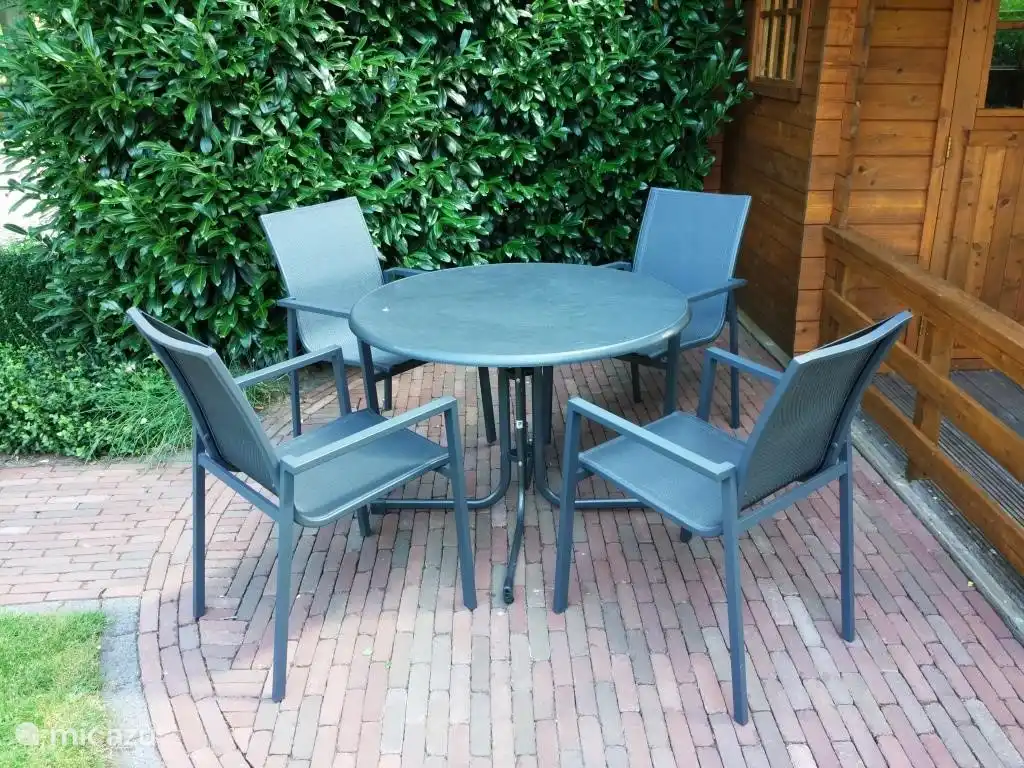 Das Gartenhaus ist ein weiterer Garten mit vier Stühlen und einem Tisch.