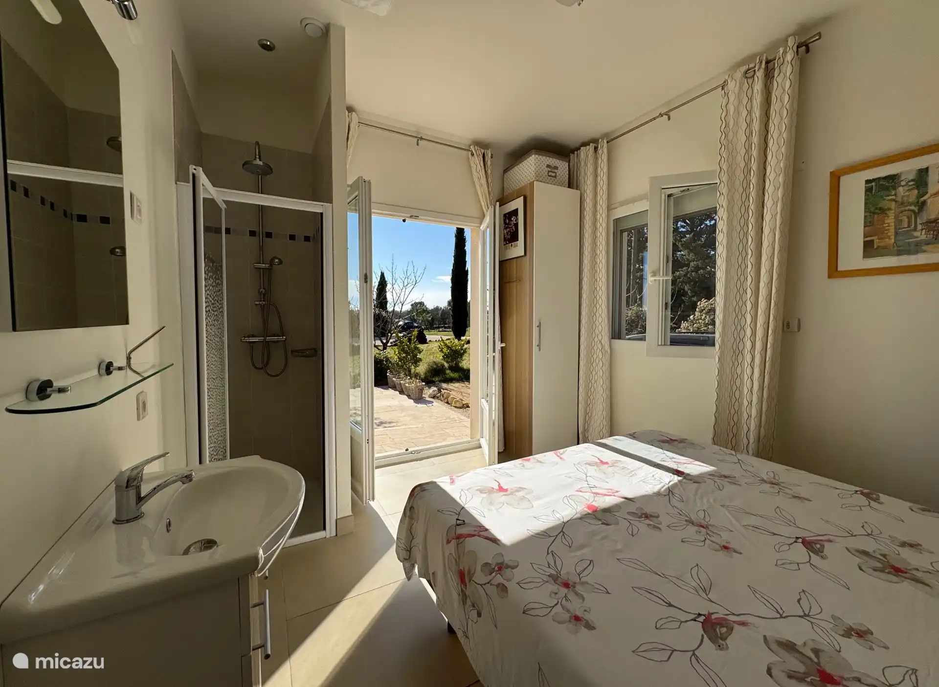 Dieses Schlafzimmer verfügt über ein Waschbecken und eine Dusche. Von den Terrassentüren aus können Sie auf die Terrasse treten.