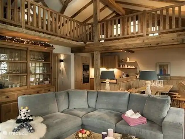 Location de Vacances Autriche, Salzburgerland, Hinterglemm, chalet - Chalet avec sauna à Hinterglemm Le salon avec mezzanine et plafond aux poutres apparentes dégage une atmosphère chaleureuse et est réalisé dans un style typiquement autrichien.