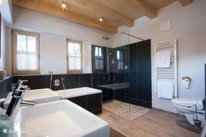 De grote badkamer heeft een ligbad, ruime douche, 2 wastafels, toilet en vloerverwarming. Luxe uitgevoerd en voorzien van alle gemakken zoals een regendouche en een normale douche.