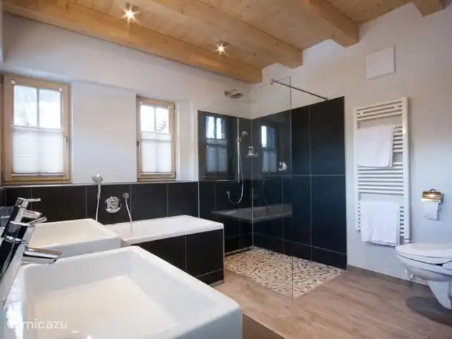 Location de Vacances Autriche, Salzburgerland, Hinterglemm, chalet - Chalet avec sauna à Hinterglemm La grande salle de bain a une baignoire, une douche spacieuse, 2 lavabos, des toilettes et un chauffage au sol. Luxueuse et équipée de toutes les commodités telles qu'une douche à effet pluie et une douche normale.