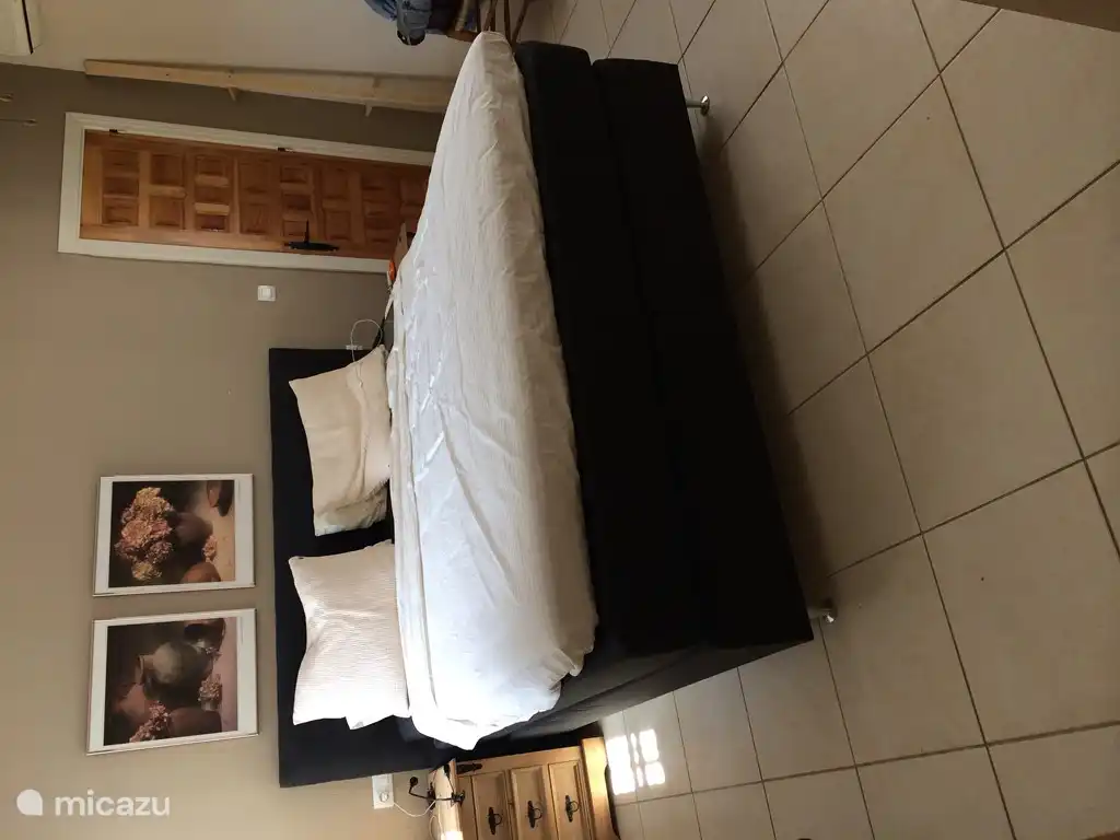 Das Hauptschlafzimmer mit einem Kingsize-sizebed, reichlich Stauraum und Durchgang zum Bad.