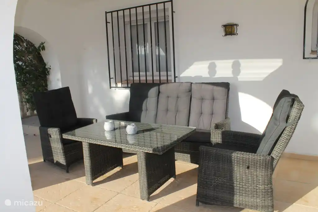 Terrasse couverte avec salon au bord de la piscine