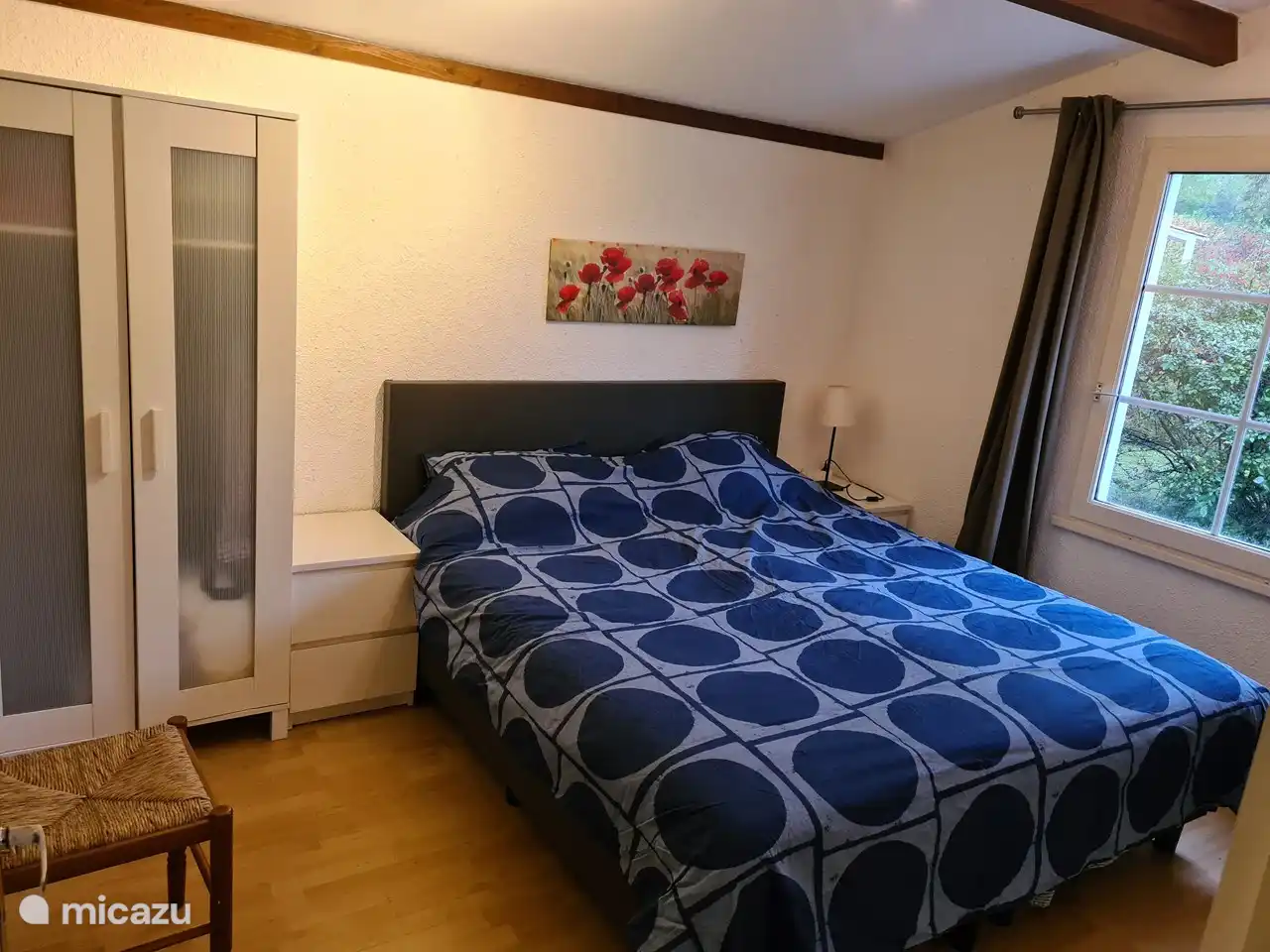 1 Schlafzimmer mit Nachttischen und einem Kleiderschrank.