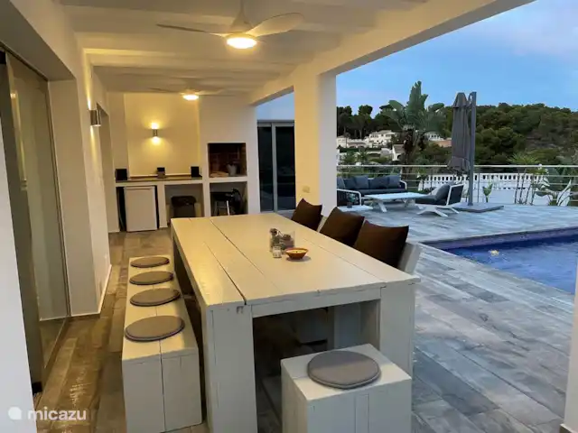 casa la fustera en España, Costa Blanca, Calpe - villa Gran mesa de comedor bajo el techo con ventiladores e iluminación.