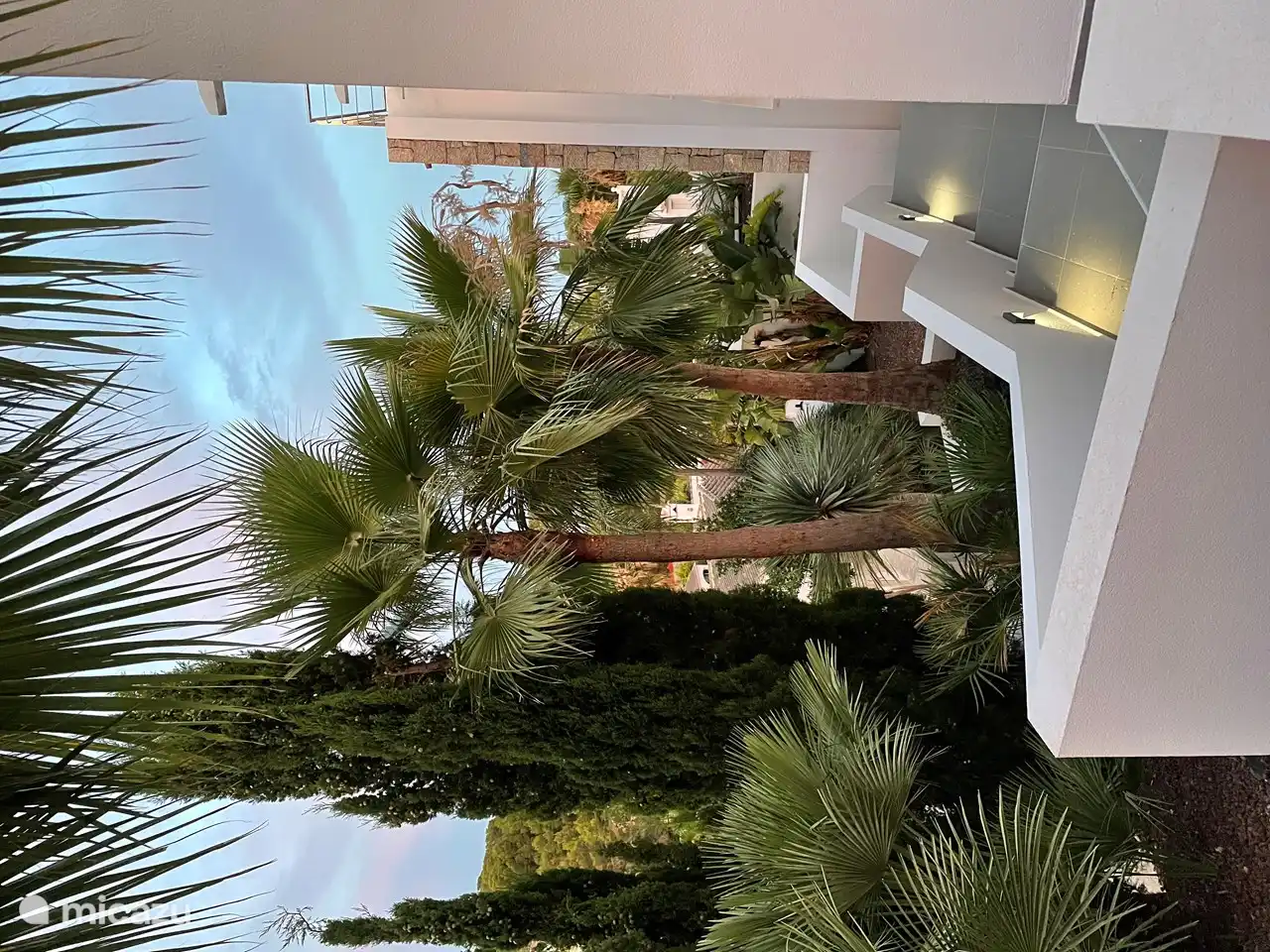 Treppe an der Seite des Hauses zur Garage und kleinem Tor mit mediterranem Garten.