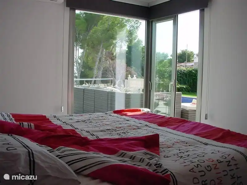 Master-Schlafzimmer mit Doppelelektro Boxspring (unabhängig arbeiten), en-suite Badezimmer und einen begehbaren Kleiderschrank. Klimaanlage selbstverständlich vorhanden und Schiebetüren zur Terrasse.