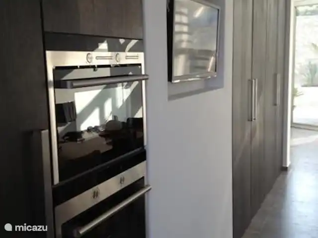 casa la fustera en España, Costa Blanca, Calpe - villa Gabinete de pared en la cocina con microondas, horno, grill y heladera grande. TV oculta en la pared.