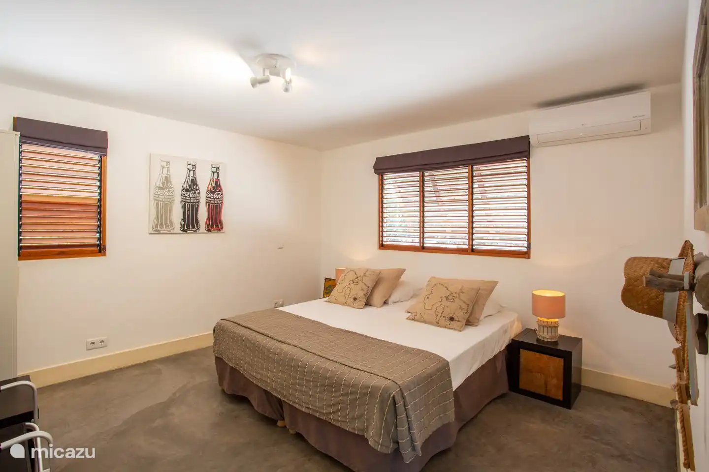 Schlafzimmer mit Kingsize-Bett, mit Klimaanlage, Kleiderschrank und Sitzgelegenheit. Betten können auch in 2 x 1 Pers aufgeteilt werden.