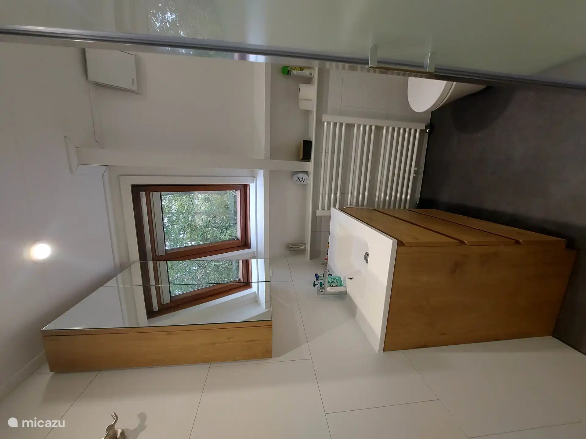 Salle de bain avec vue sur les arbres, équipée d'une cabine de douche confortable et du chauffage central