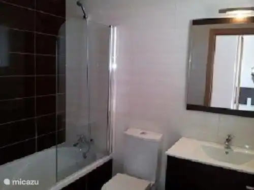 One of the three bathrooms. This bathroom has a bath / shower, toilet and sink.