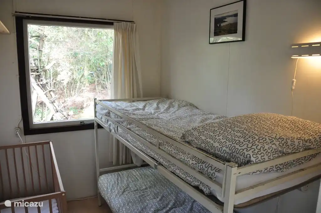 Schlafzimmer 2 verfügt über ein Etagenbett und ein Kinderbett.