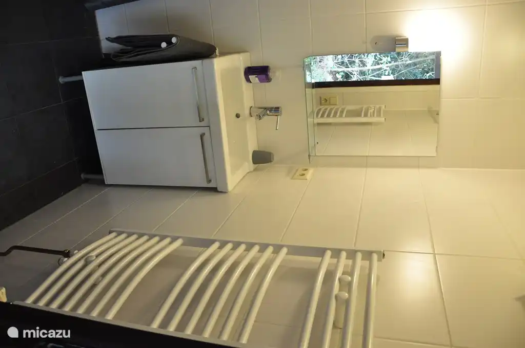 Das Badezimmer mit Dusche, Waschbecken und Handtuchtrockner. Das Badezimmer verfügt über Fußbodenheizung.