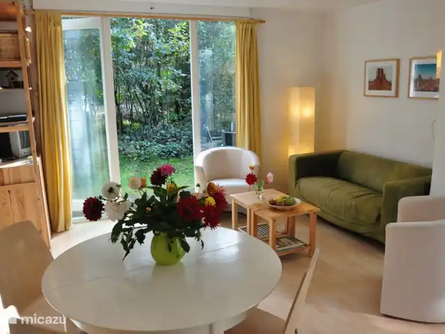 Mezennest 79 | Pays-Bas, Gueldre, Nunspeet - bungalow Le chaleureux salon avec porte-patio, grande façade vitrée et poêle à bois (pas encore de photo disponible). Vue de la terrasse.