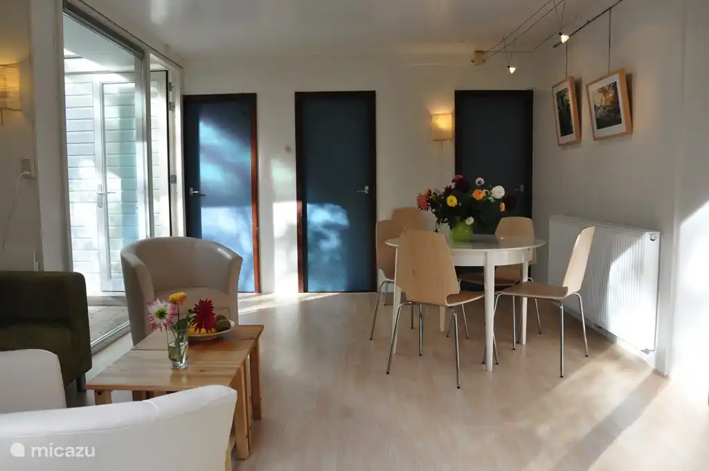 Das helle Wohnzimmer mit ausziehbarer Esstisch und Sitzecke.