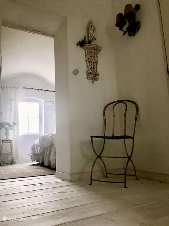 Die Holztreppe mit Kronleuchter bringt Sie in die obere Etage