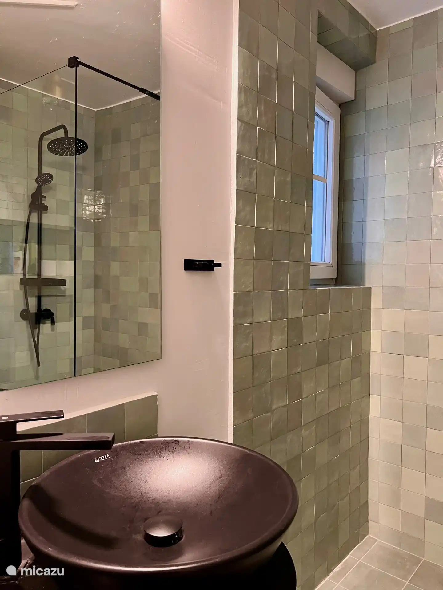 Salle de bain avec douche à l’italienne et toilettes.