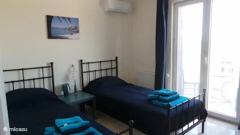 Bedroom with 2 beds, air conditioning, patio doors to balcony
