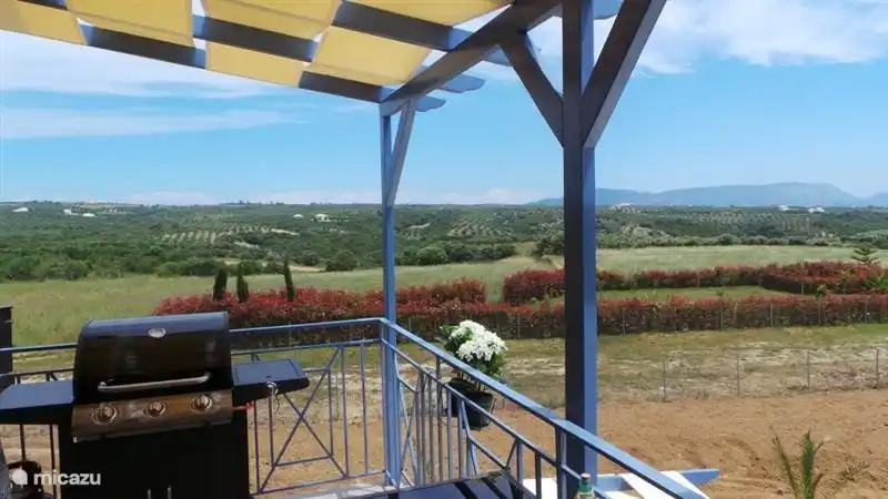 View from large terrace (with large dining table and 4 garden chairs) with outdoor kitchen on gas.