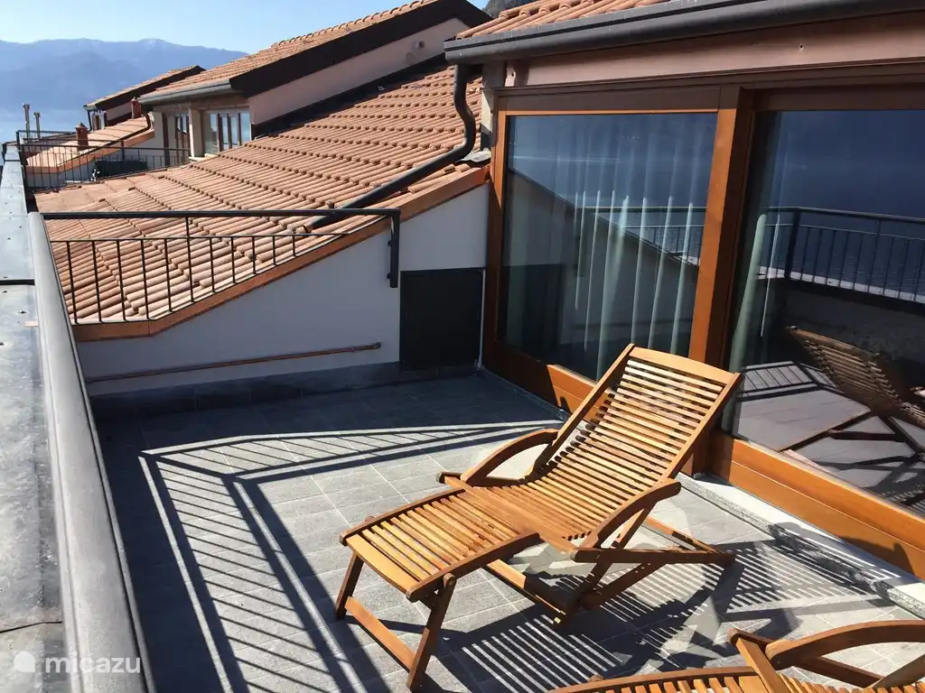 El apartamento tiene una terraza en la azotea con una vista despejada del lago y las montañas.