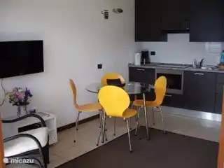 El comedor tiene capacidad para 4 personas. La cocina abierta tiene placa de inducción, grill/microondas y muchos utensilios de cocina, cubertería y vajilla.