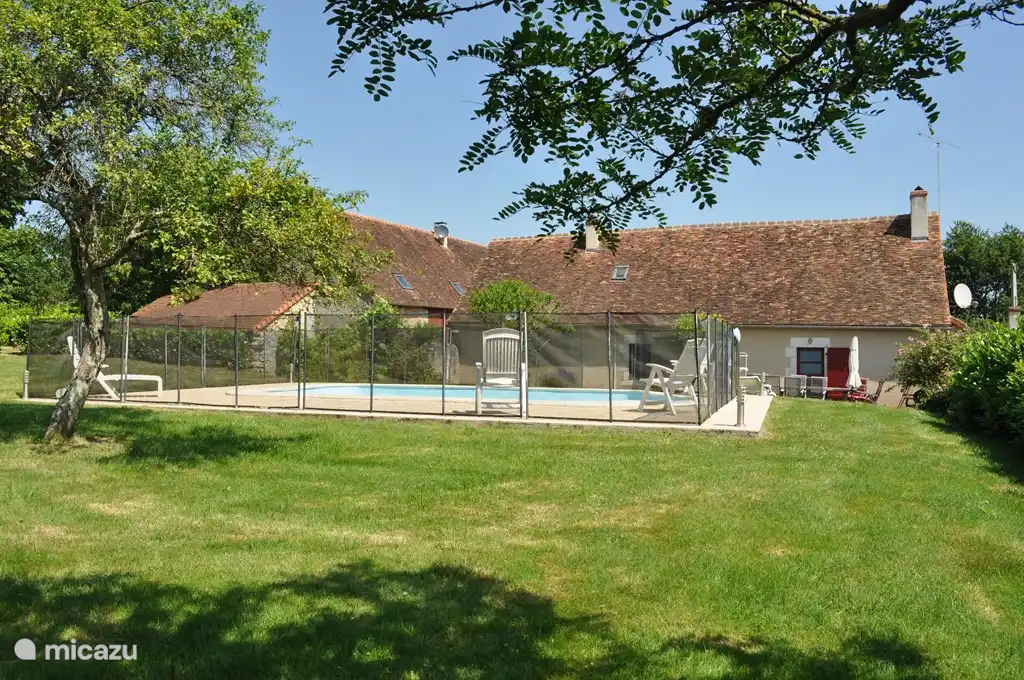 Jardin avec piscine, la terrasse est située juste derrière la piscine