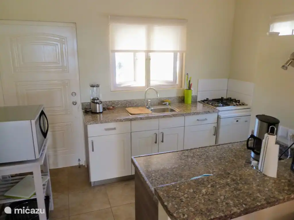 Geräumige Küche mit vier Flammen-Gasherd, Geschirrspüler und Mikrowelle.