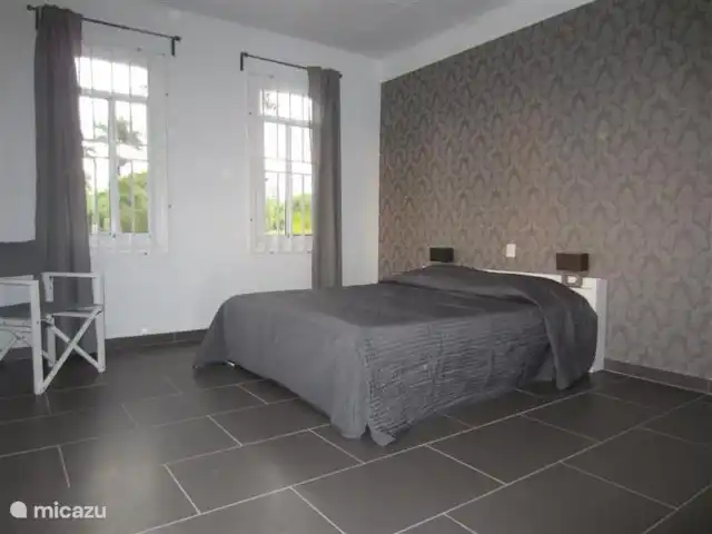 casa vacacional en Surinam, Wanica, Dirección – A la vuelta de la esquina dormitorio 1, cama doble, armario y aire acondicionado.
