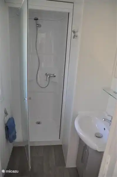 Badezimmer mit Dusche und Waschbecken.