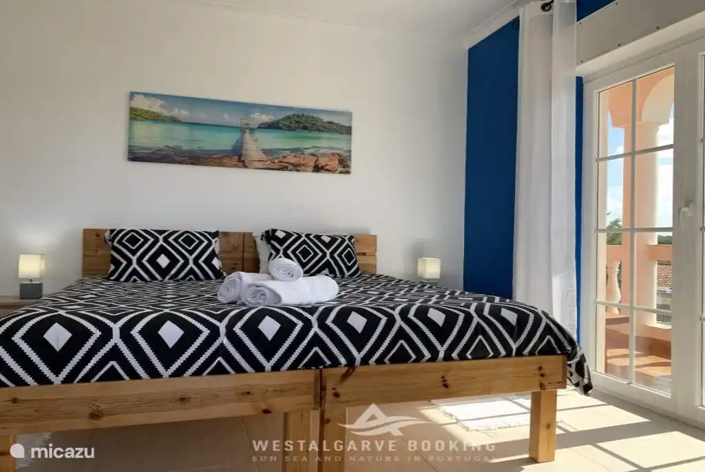 Slaapkamer met 2 enkele bedden, met balkon.
