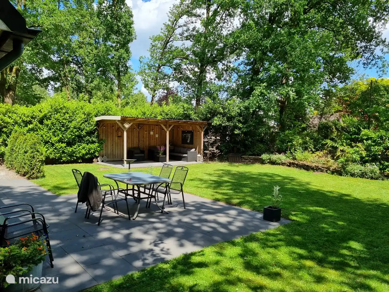 Hinterhaus mit einem Baldachin auf der Rückseite des Gartens zum Entspannen.