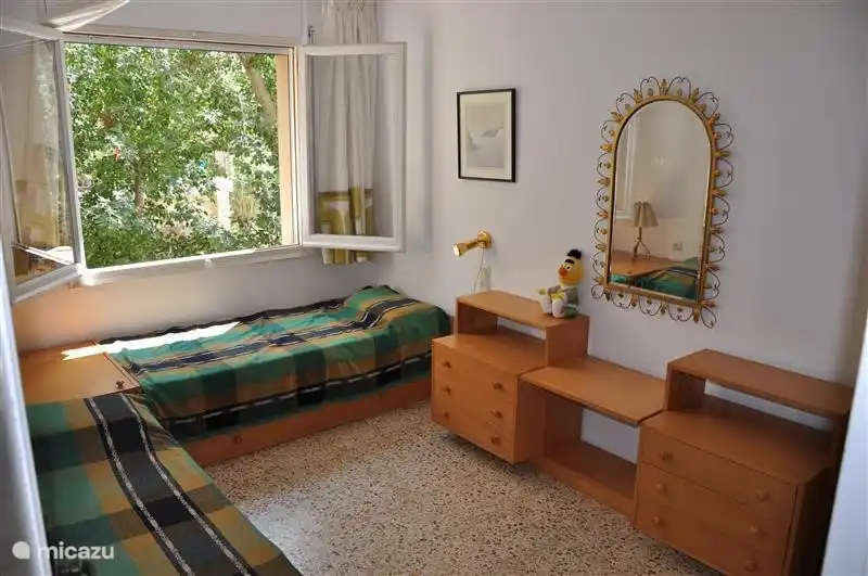 Dormitorio con 2 camas individuales y vista a los árboles.