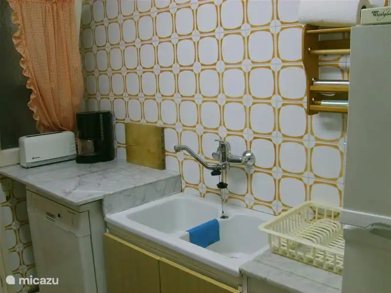 cocina con estufa de gas, lavavajillas, lavadero con lavadora