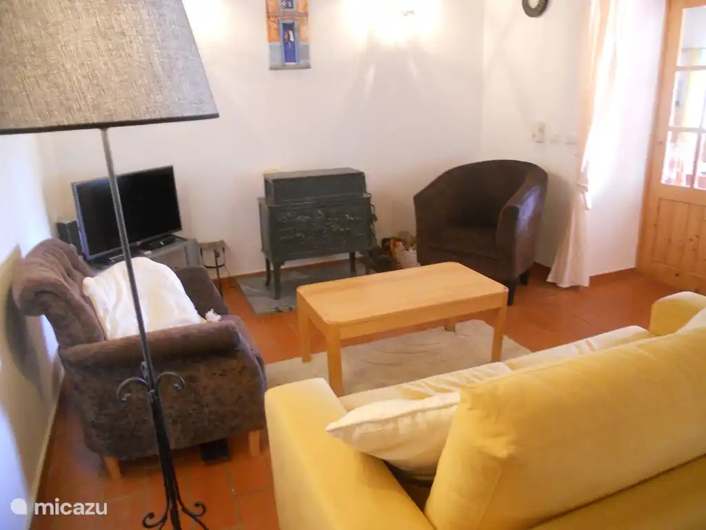 Das Wohnzimmer mit Holzofen und Fernseher. Empfang aller niederländischen Kanäle und mehr in HD-Qualität.