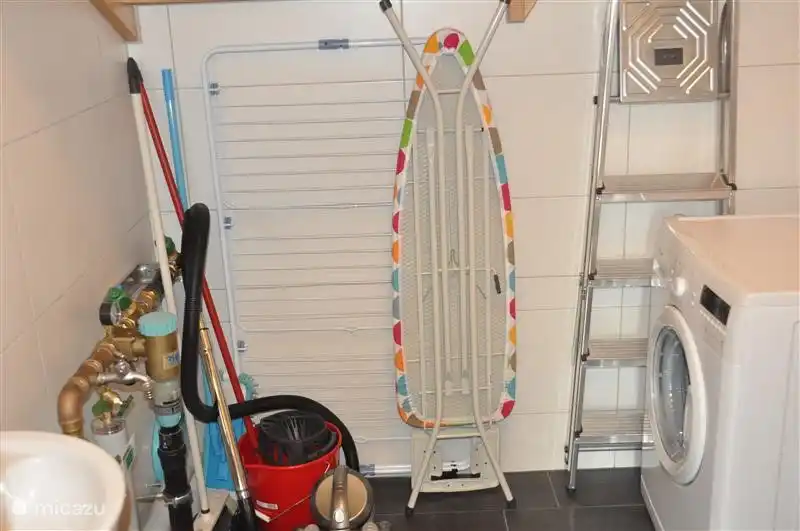machine à laver et planche à repasser dans le débarras