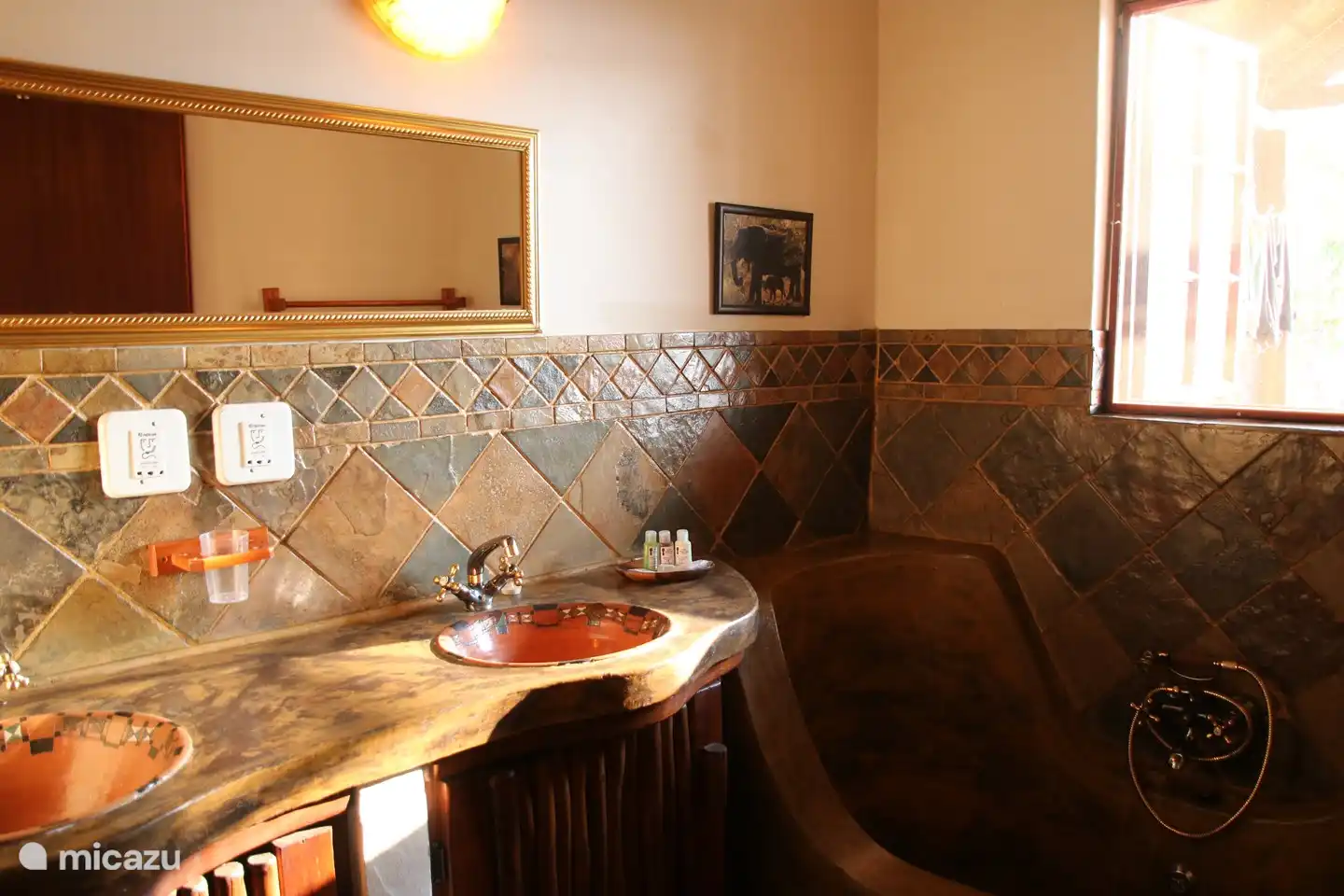 Große Badewanne im afrikanischen Stil mit Handbrause.