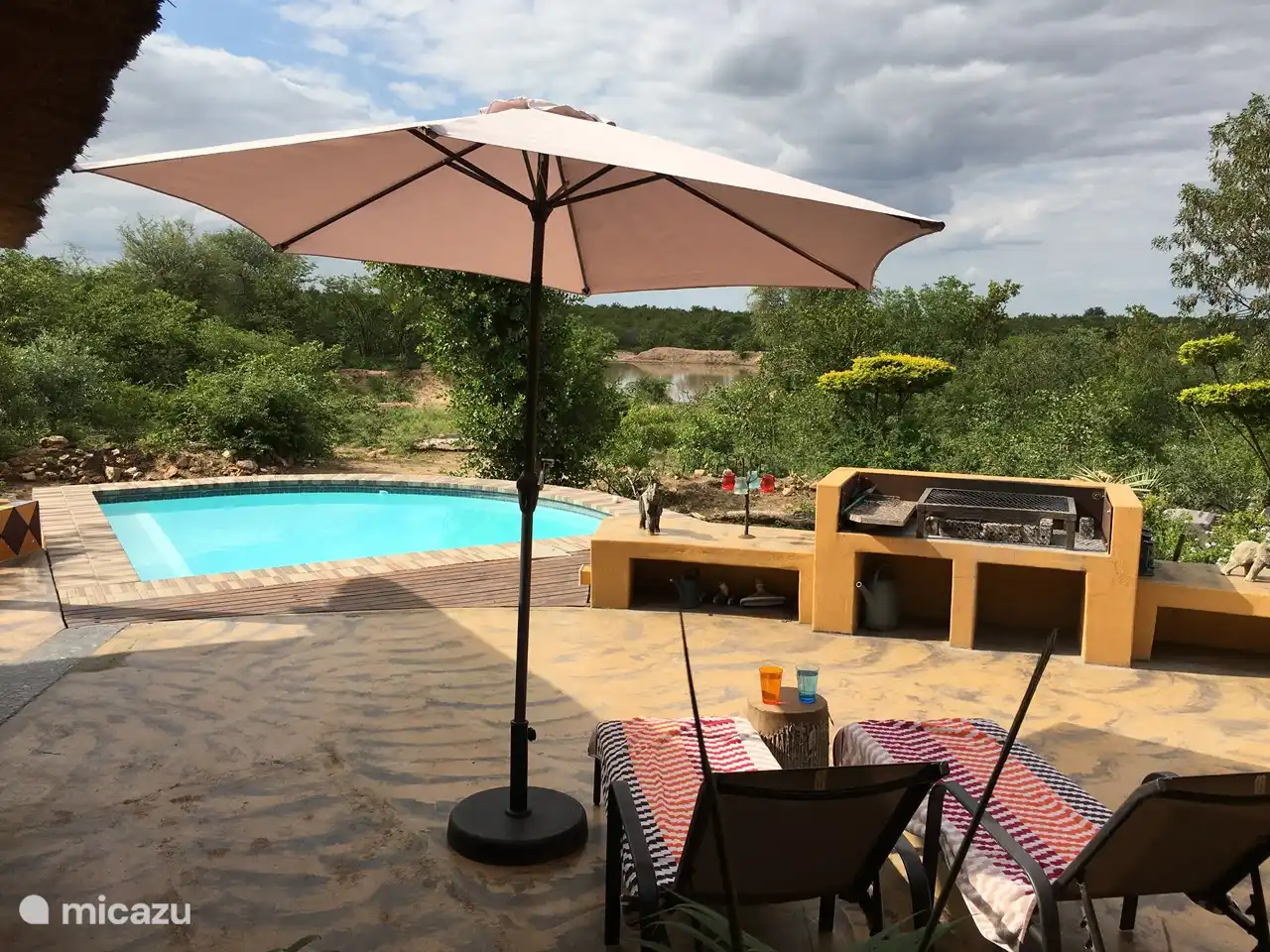 2. Terrasse, die Poolterrasse, hat zwei Liegestühle, zwei normale Stühle und hat einen Blick auf den Damm.