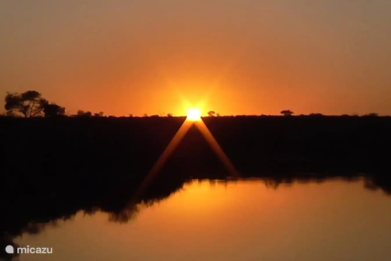 Sonnenuntergang über dem Damm, der von Regenzeit gefüllt wird.