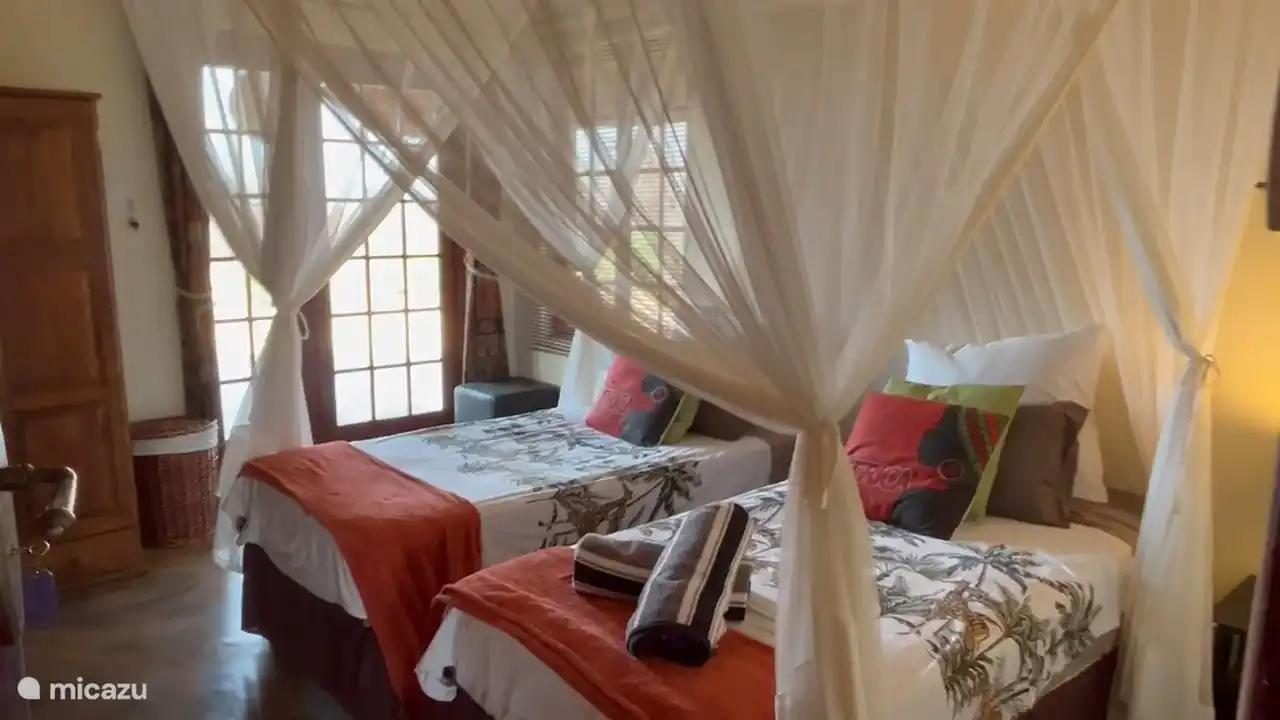 Schlafzimmer 3, etwas kleinere Betten und kleineres Schlafzimmer. Dieses Zimmer bietet Zugang zu einer halbprivaten Terrasse mit Blick auf den Busch und den Krügerpark am Horizont.