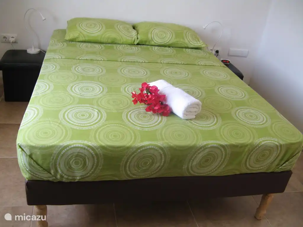 Master bedroom, avec un lit double et une armoire ouverte. La climatisation split-unit fournit la fraîcheur nécessaire pour que vous dormiez merveilleusement ici. Il y a aussi un ventilateur mobile.