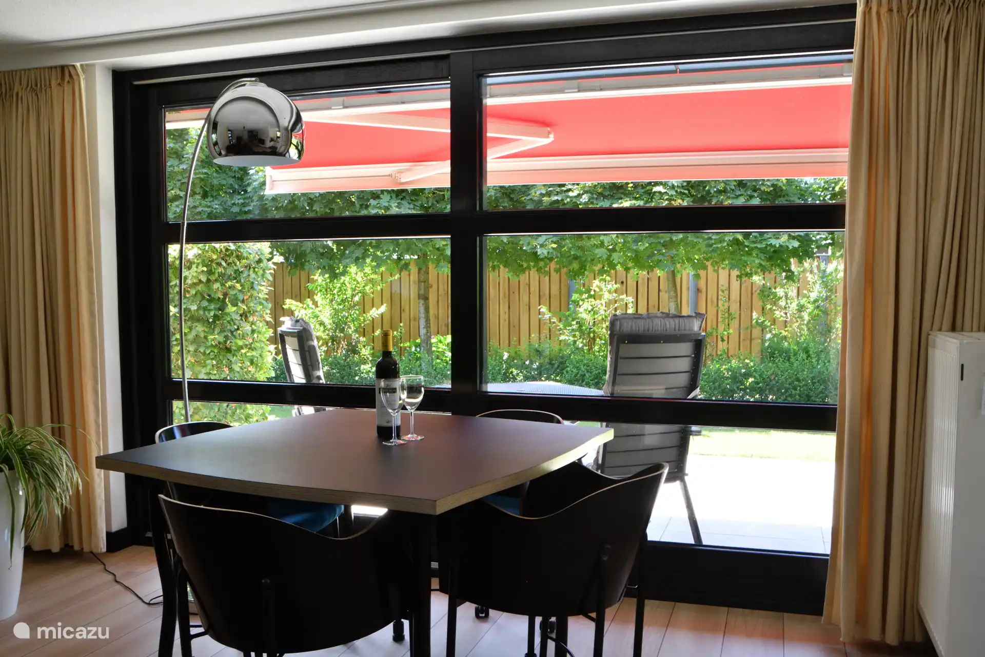 Een doorkijkje vanuit de woonkamer in de ruimte privé tuin. 