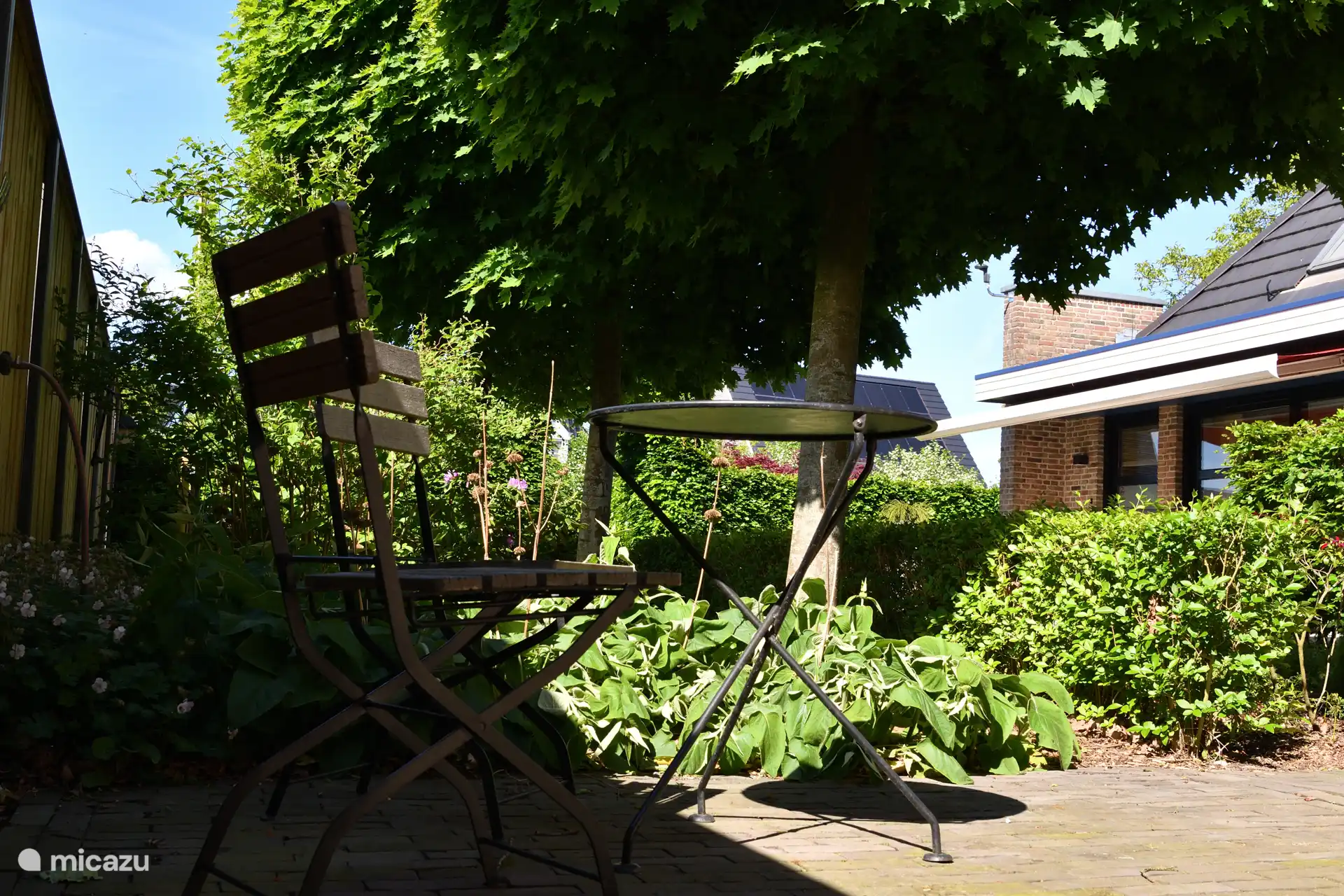 Een doorkijkje vanaf het zitje op de eigen inrit richting de terras zijde van de woning