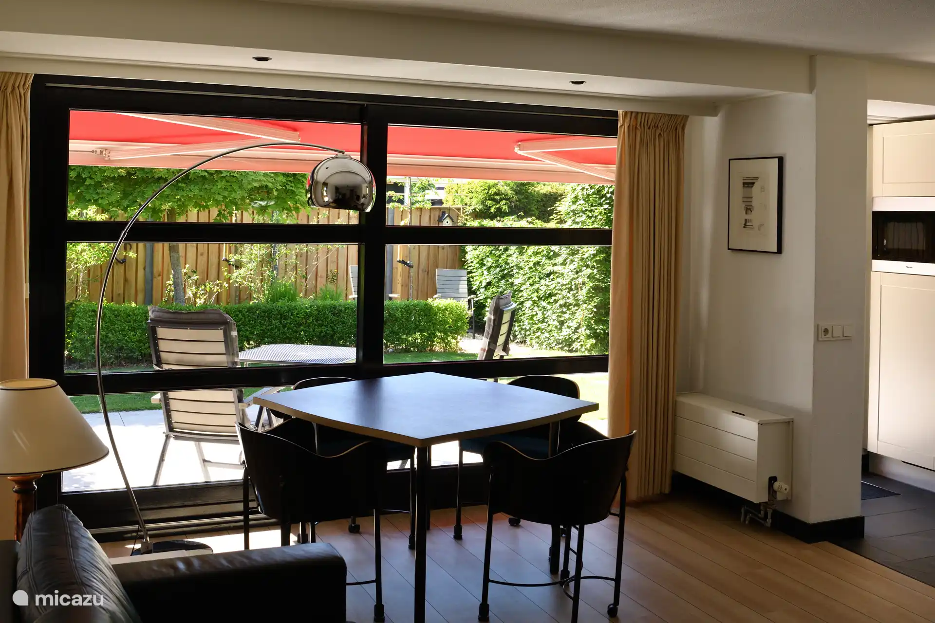 Vanuit de woonkamer direct toegang tot het terras, de privé tuin en een extra zitje achter in de tuin. 