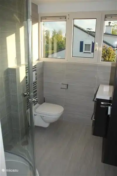 Im Obergeschoss Bad mit Dusche, WC, Schrank und Waschbecken