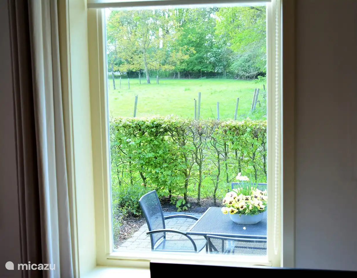 Blick auf Terrasse, Wiese und Waldrand vom Zimmer aus