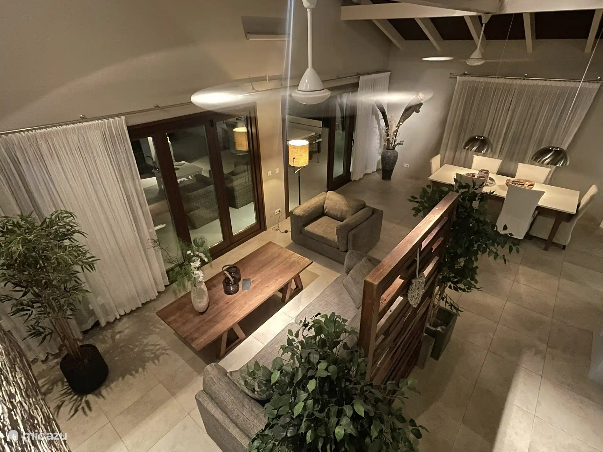De woonkamer met open keuken (aan de rechterzijde).