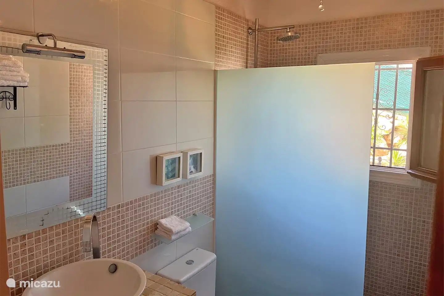 Wohnung im Obergeschoss: Das helle Badezimmer verfügt über eine begehbare Dusche mit Regendusche und Handbrause, Waschbecken und Toilette.