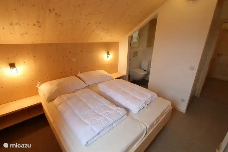 Schlafzimmer mit eigenem Bad. Mit WC, Dusche und Waschbecken.